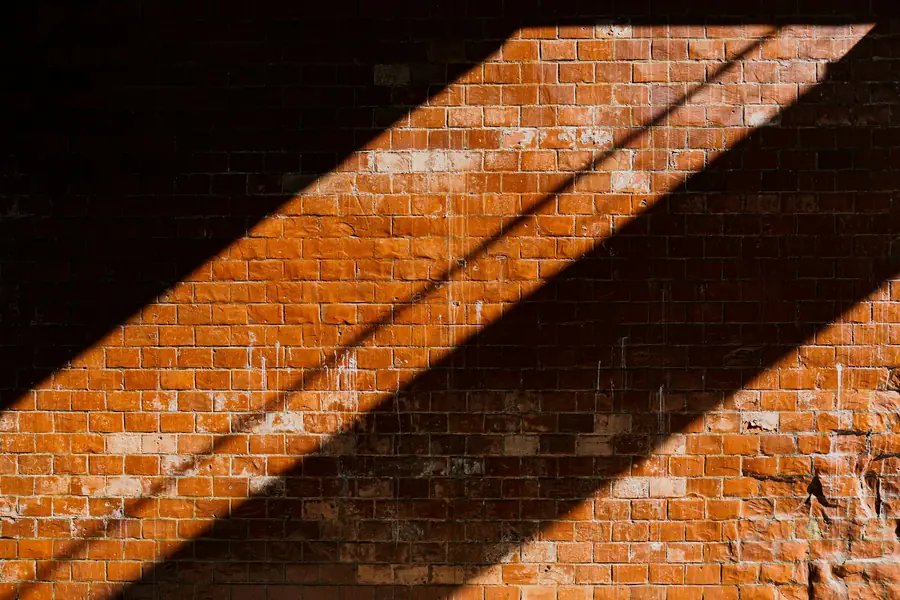 Clay brick wall with a raking shadow