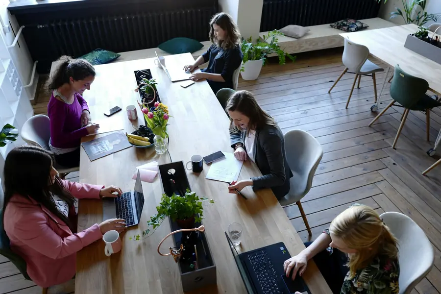 People working at a long timber table