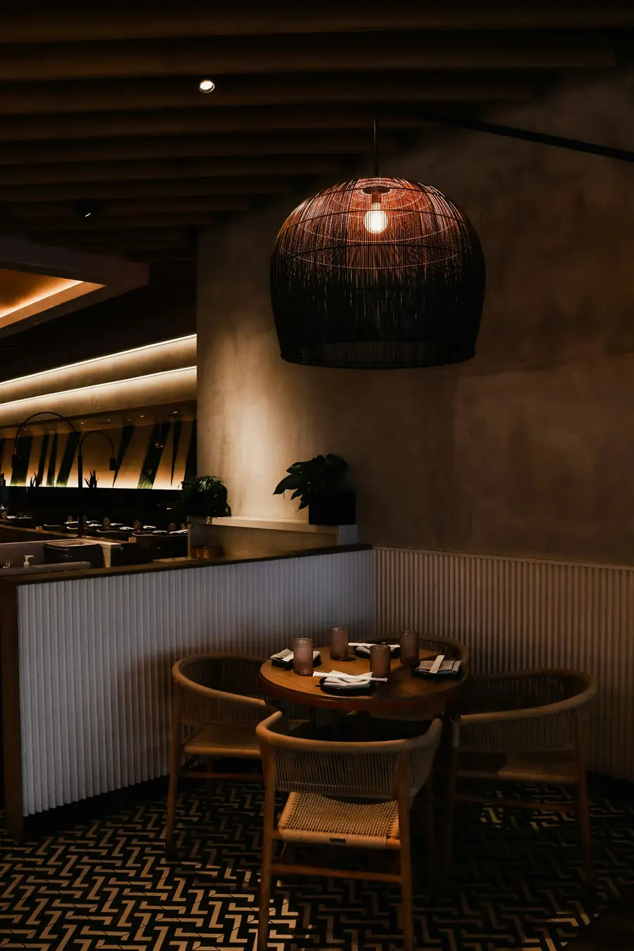 Restaurant with a woven pendant lamp over a round table